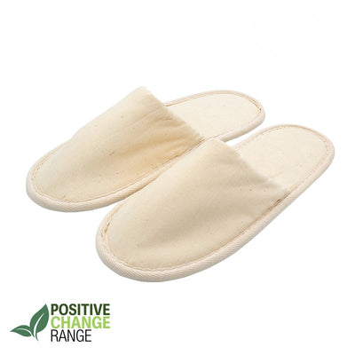 Pair of beige eco-friendly fabric slippers with closed toes, labeled Positive Change Range on white background.
