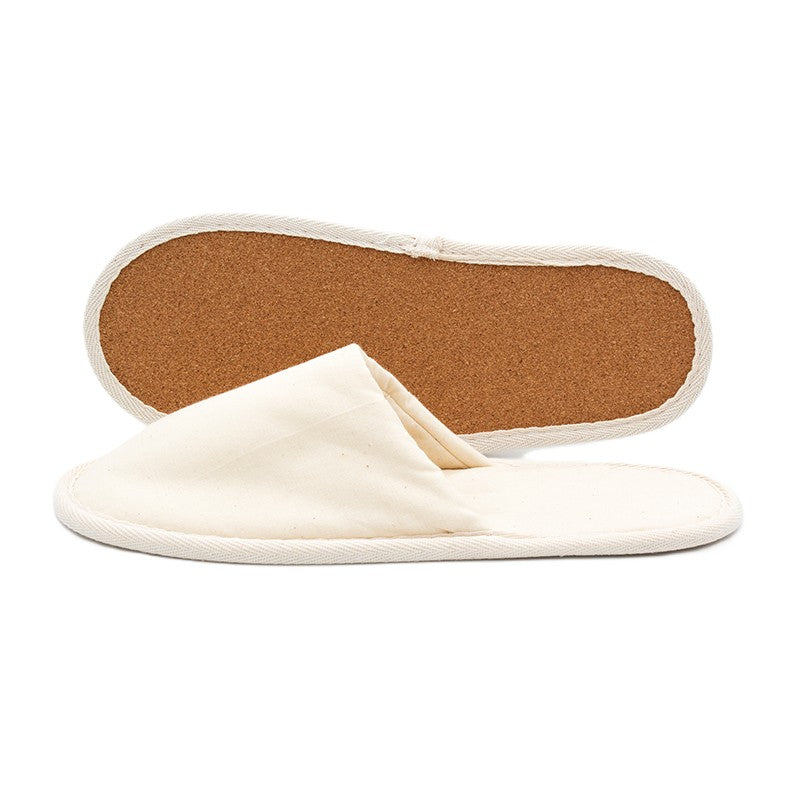 Pair of beige fabric slippers, one showing the cork sole and the other displaying the closed-toe upper.