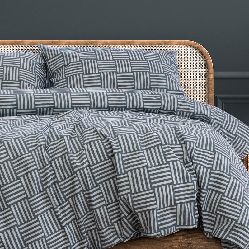 Fletcher quilt cover set on bed with blue and white geometric pattern and pillows
