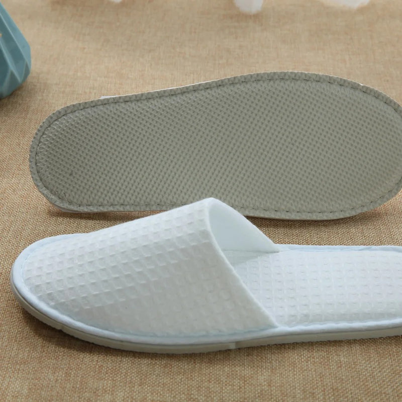 White men’s waffle slippers with open toe and textured design, ideal for hotel or spa comfort.