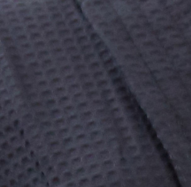 black waffle weave fabric texture with soft, raised square pattern