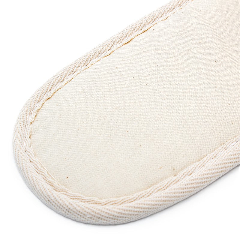 beige fabric slipper sole with stitched edges, showing its simple texture and design.