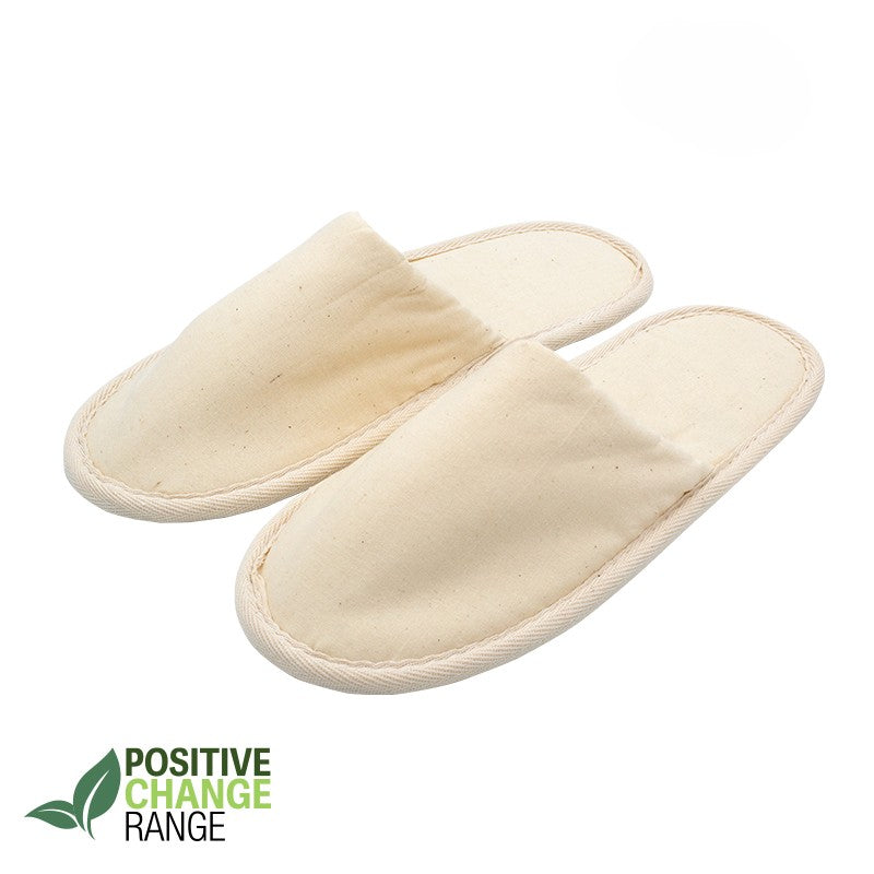Pair of beige eco-friendly fabric slippers with closed toes, labeled Positive Change Range on white background.
