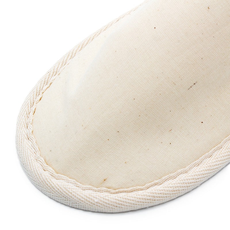 beige fabric slipper showing the stitched edge and texture of the material