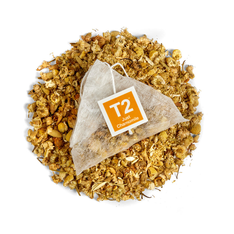 Tea bag with T2 label on a bed of dried chamomile flowers