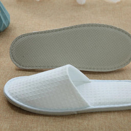 White men’s waffle slippers with open toe and textured design, ideal for hotel or spa comfort.