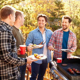 Guys having a barbeque with mates and cooking