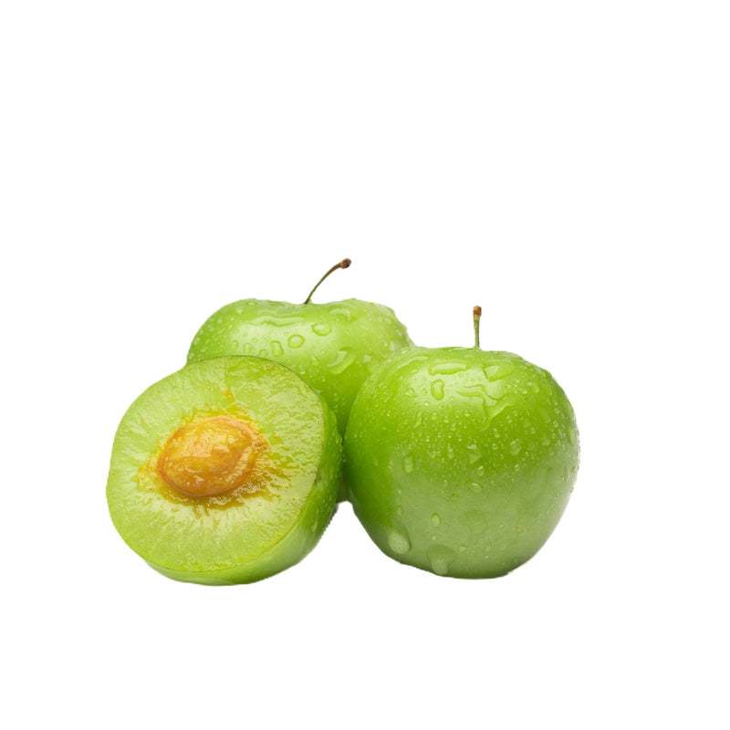Fresh green plums with water droplets, one cut open to show the pit inside