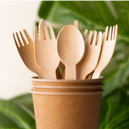 Wooden cutlery in cup with leaves-500×500