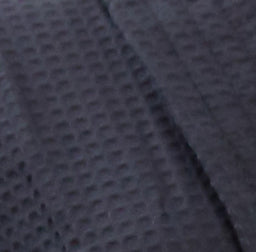 black waffle weave fabric texture with soft, raised square pattern