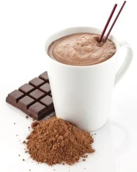 Cup of hot chocolate topped with frothy milk, served in a white mug on a saucer.
