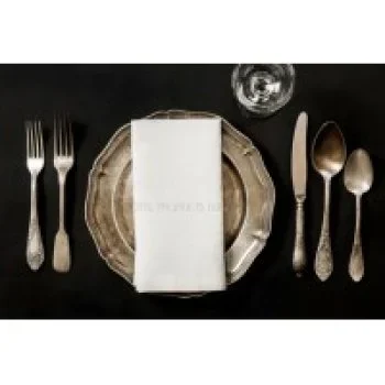 Elegant black table setting with plates, cutlery, and glassware arranged neatly for dining.
