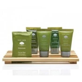 Basic Earth toiletry set displayed on a small tray, including shampoo, conditioner, and body lotion.